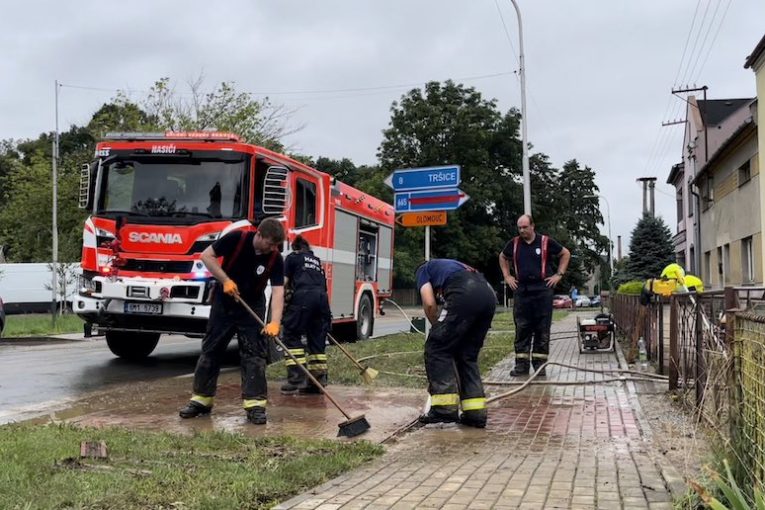 Úklid zaplavené ulice po bouřce